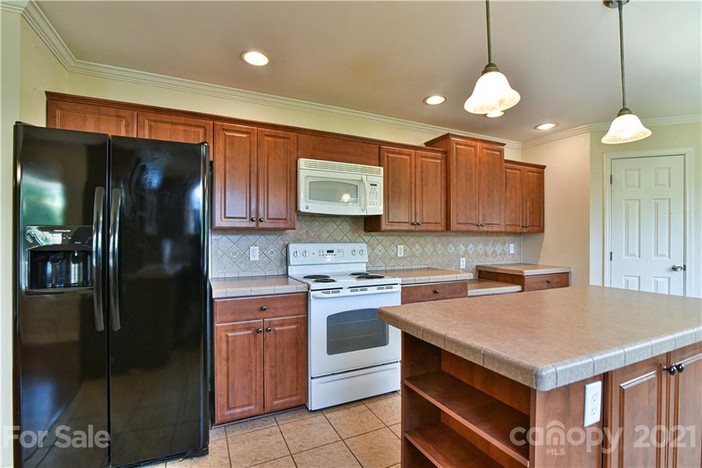 699 Pleasant Hill Road Clyde, NC 28721 - Photo 12 of 32 a kitchen with a stove a refrigerator a sink and dishwasher with wooden cabinets