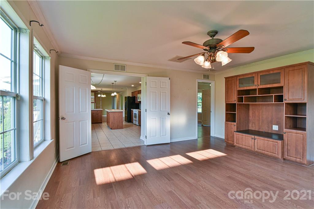 699 Pleasant Hill Road Clyde, NC 28721 - Photo 14 of 32 a view of a livingroom with wooden floor and a ceiling fan