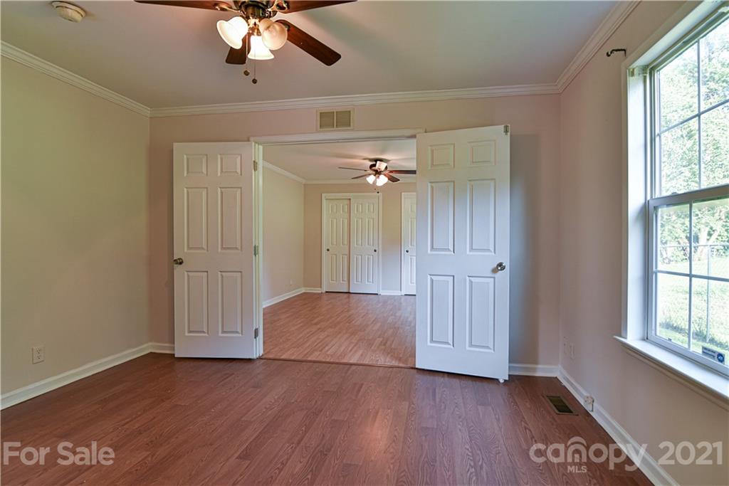699 Pleasant Hill Road Clyde, NC 28721 - Photo 18 of 32 a view of an empty room with a window and wooden floor