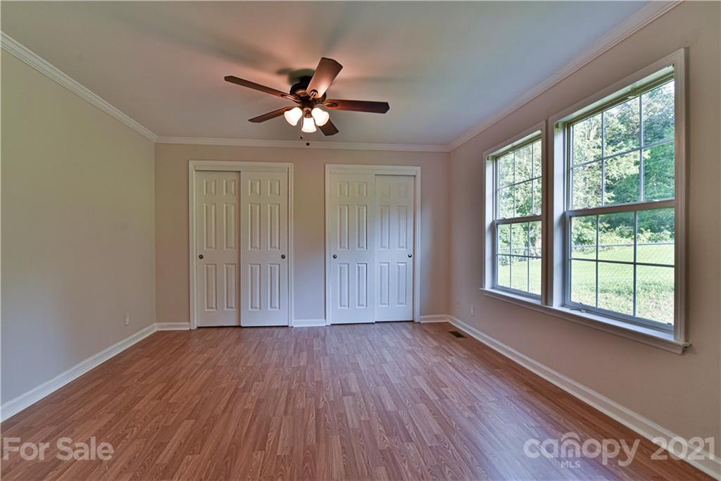 699 Pleasant Hill Road Clyde, NC 28721 - Photo 19 of 32 a view of an empty room with a window and wooden floor