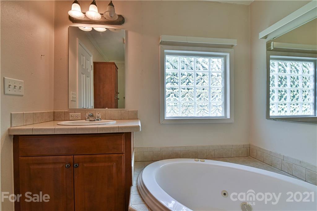 699 Pleasant Hill Road Clyde, NC 28721 - Photo 21 of 32 a bathroom with a bathtub a sink and a mirror