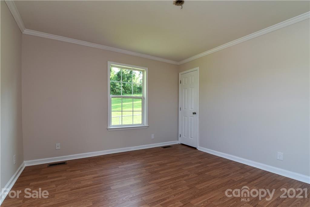699 Pleasant Hill Road Clyde, NC 28721 - Photo 26 of 32 an empty room with wooden floor and windows