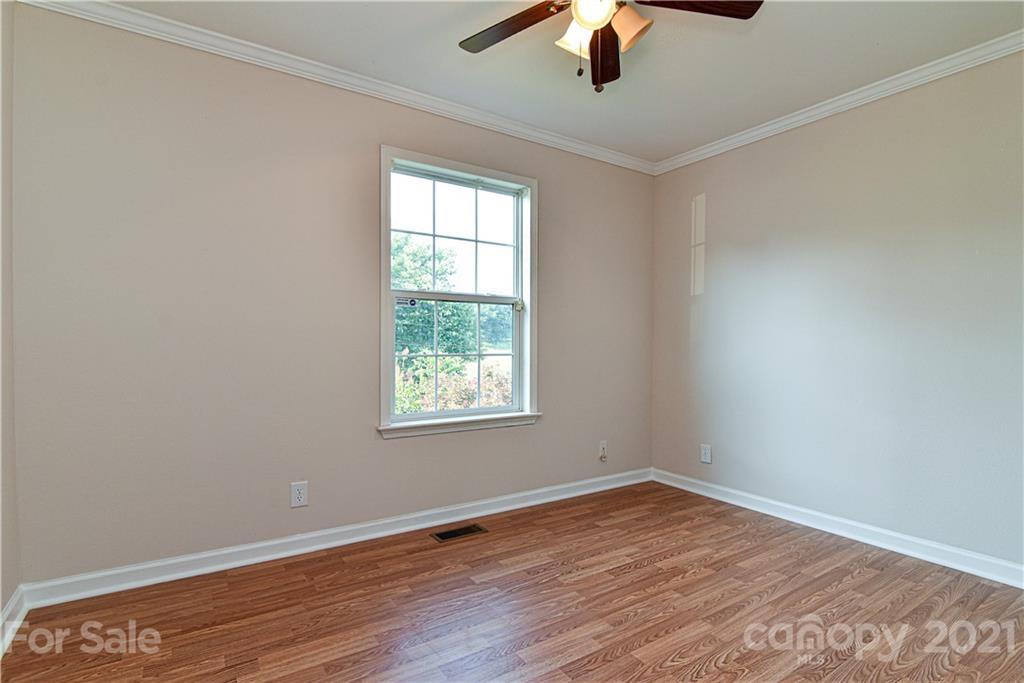 699 Pleasant Hill Road Clyde, NC 28721 - Photo 28 of 32 an empty room with a window and a ceiling fan