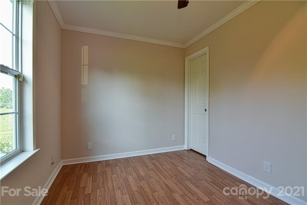 699 Pleasant Hill Road Clyde, NC 28721 - Photo 29 of 32 a view of an empty room with wooden floor and a window