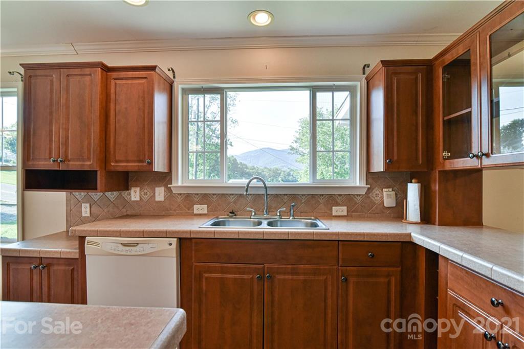 699 Pleasant Hill Road Clyde, NC 28721 - Photo 9 of 32 a kitchen with stainless steel appliances wooden cabinets a sink and a large window