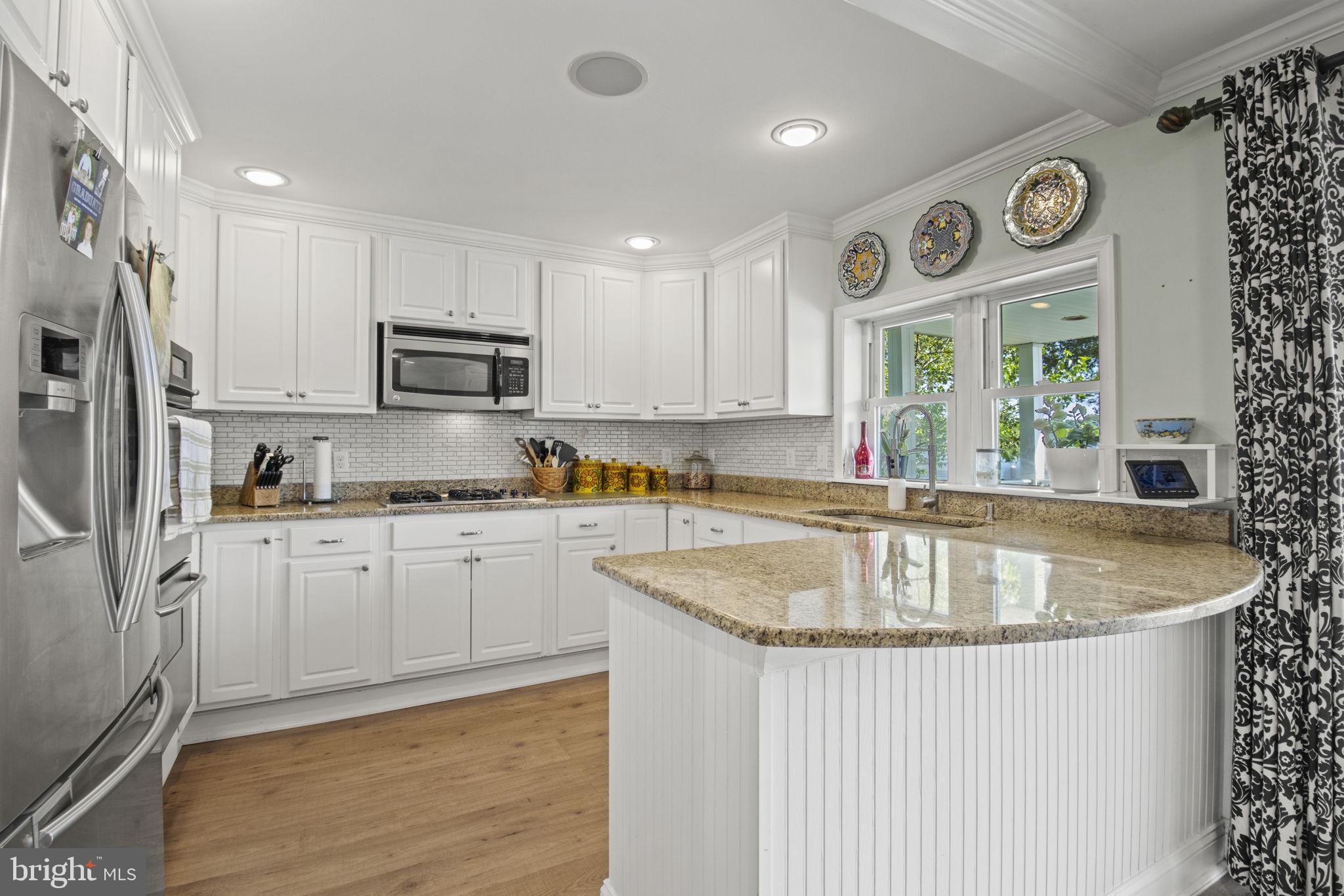 8646 Sandy Plains Road Dundalk, MD 21222 - Photo 7 of 38 a kitchen with stainless steel appliances granite countertop a sink a stove and a refrigerator