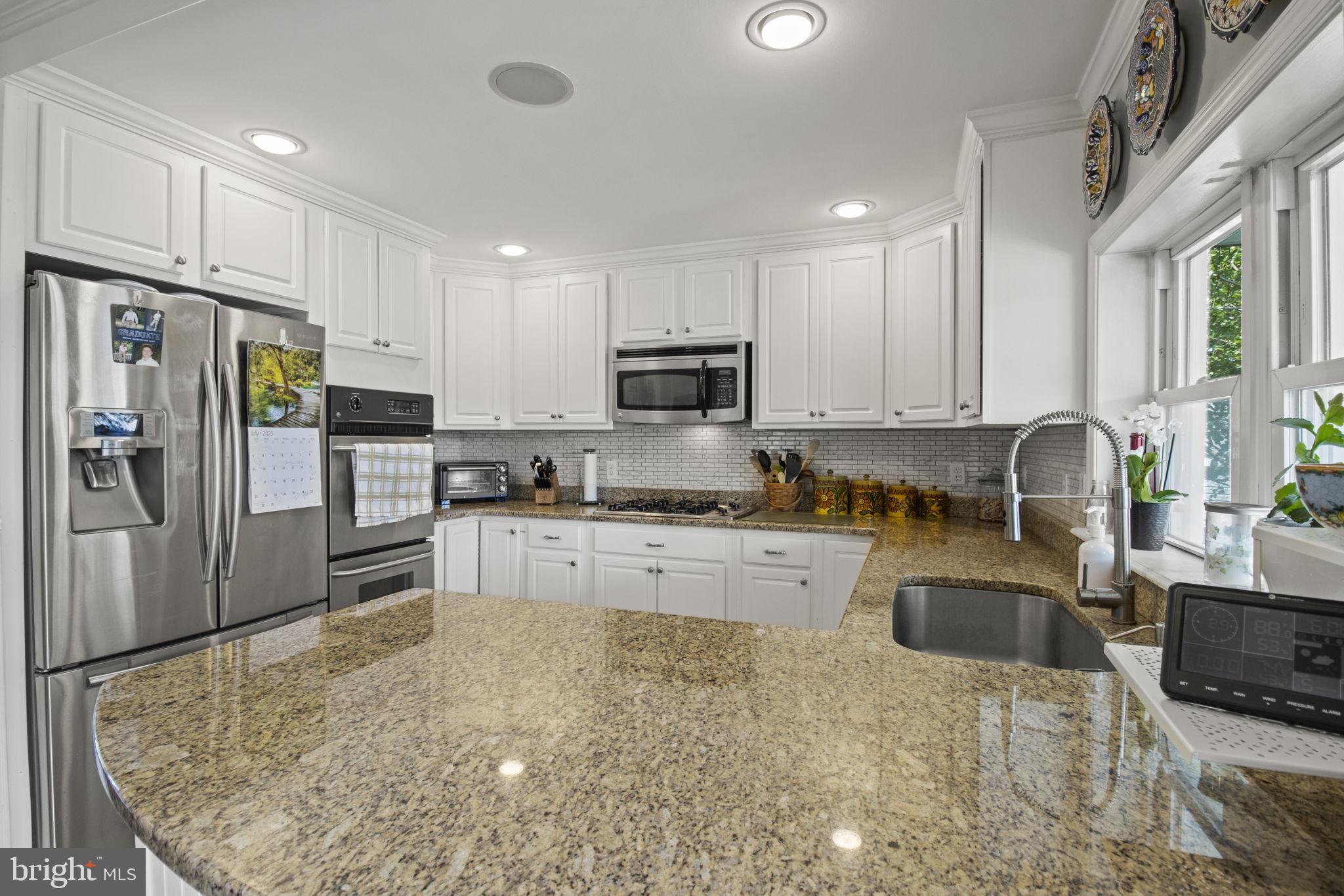 8646 Sandy Plains Road Dundalk, MD 21222 - Photo 9 of 38 a kitchen with granite countertop a refrigerator sink and microwave