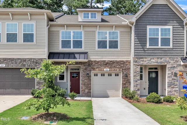 a front view of a house with a garden and plants