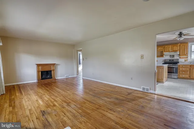 a view of empty room with wooden floor and fireplace