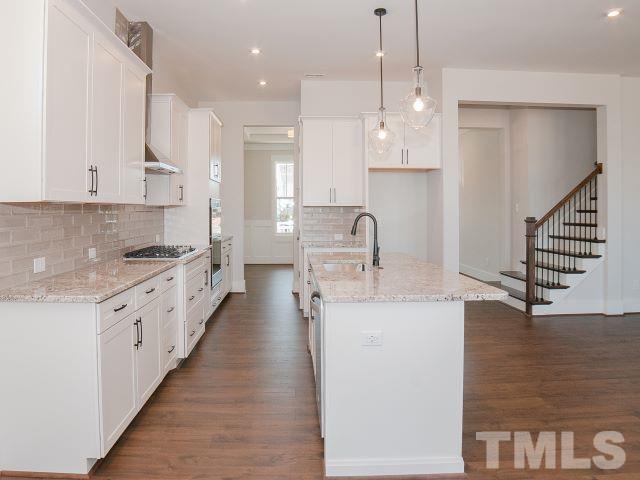 5205 Windmere Chase Drive Raleigh, NC 27616 - Photo 11 of 39 a kitchen with counter top space sink stove and cabinets