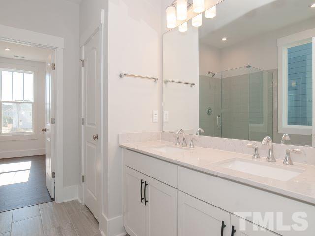 5205 Windmere Chase Drive Raleigh, NC 27616 - Photo 22 of 39 a bathroom with a granite countertop sink mirror and a shower