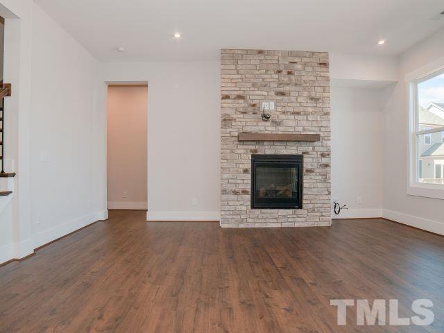 5205 Windmere Chase Drive Raleigh, NC 27616 - Photo 5 of 39 an empty room with wooden floor a fireplace and windows