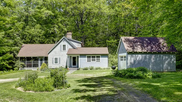 a front view of a house with a yard and green space