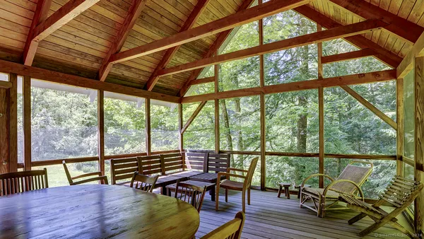 a balcony with wooden floor and outdoor seating
