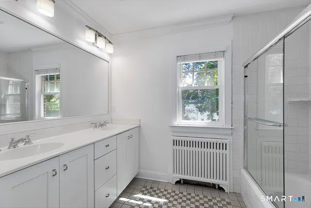 a bathroom with a sink window and a mirror