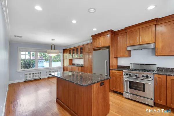 a kitchen with stainless steel appliances granite countertop a stove a sink and a refrigerator