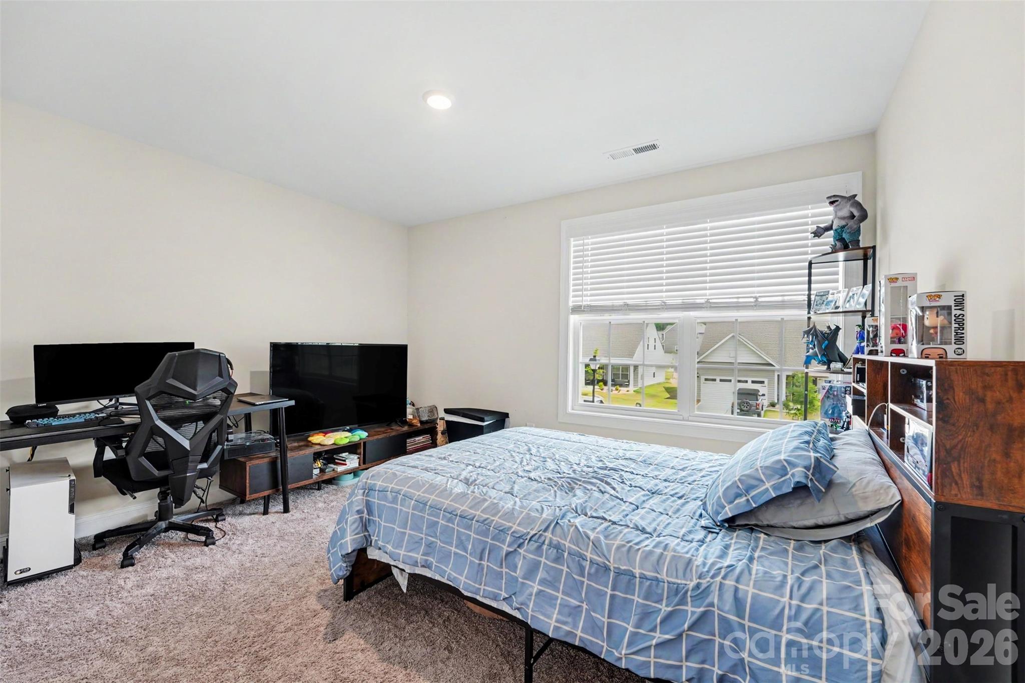 123 Brixham Loop Troutman, NC 28166 - Photo 2 of 18 a bedroom with a bed and a flat screen tv