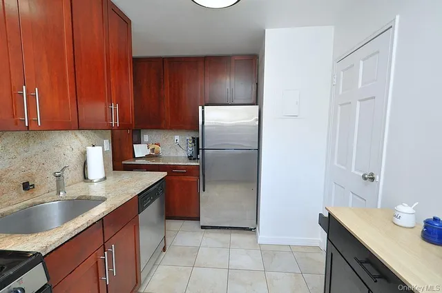 a kitchen with stainless steel appliances granite countertop a refrigerator and a sink