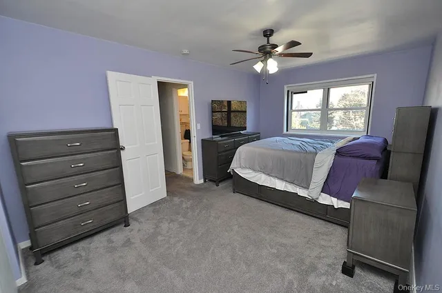 a spacious bedroom with a bed and flat screen tv