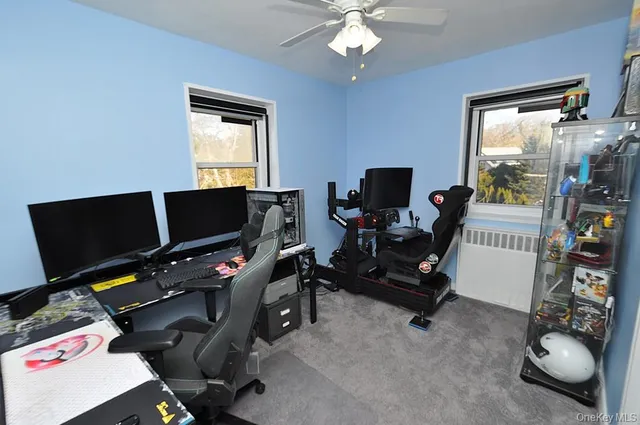 a view of a workspace with furniture and a window