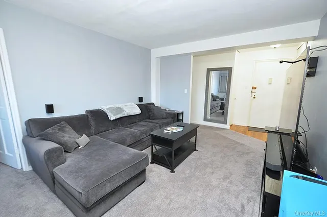 a living room with furniture and a air conditioner vent