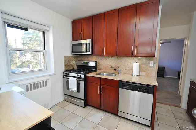 a kitchen with stainless steel appliances granite countertop a stove a sink dishwasher and a refrigerator
