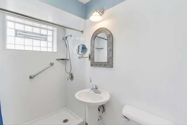 a bathroom with a sink toilet and a mirror