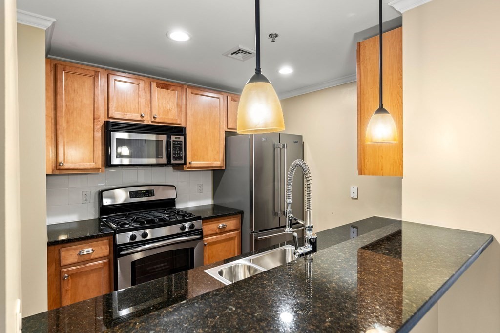 17 Central Street, Unit 9 Salem, MA 01970 - Photo 5 of 27 a kitchen with stainless steel appliances granite countertop a sink a stove and a refrigerator