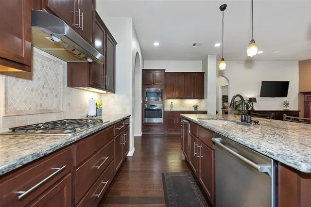 a large kitchen with stainless steel appliances granite countertop a stove a sink and a granite counter tops