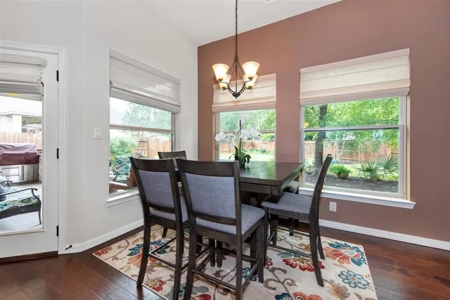 a view of a dining room with furniture a chandelier and wooden floor