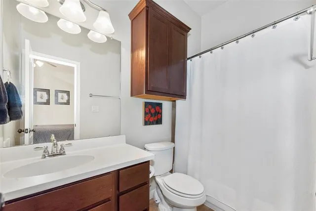 a bathroom with a sink vanity mirror and toilet