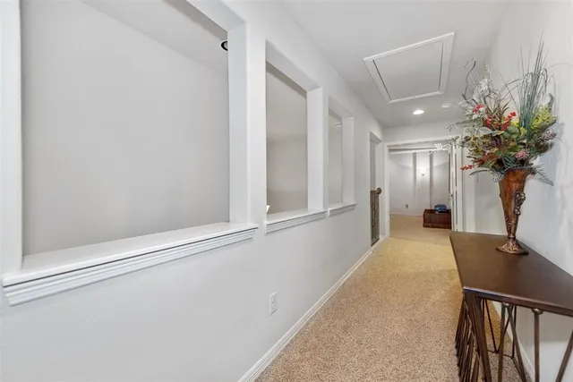 a view of a hallway with furniture and a potted plant