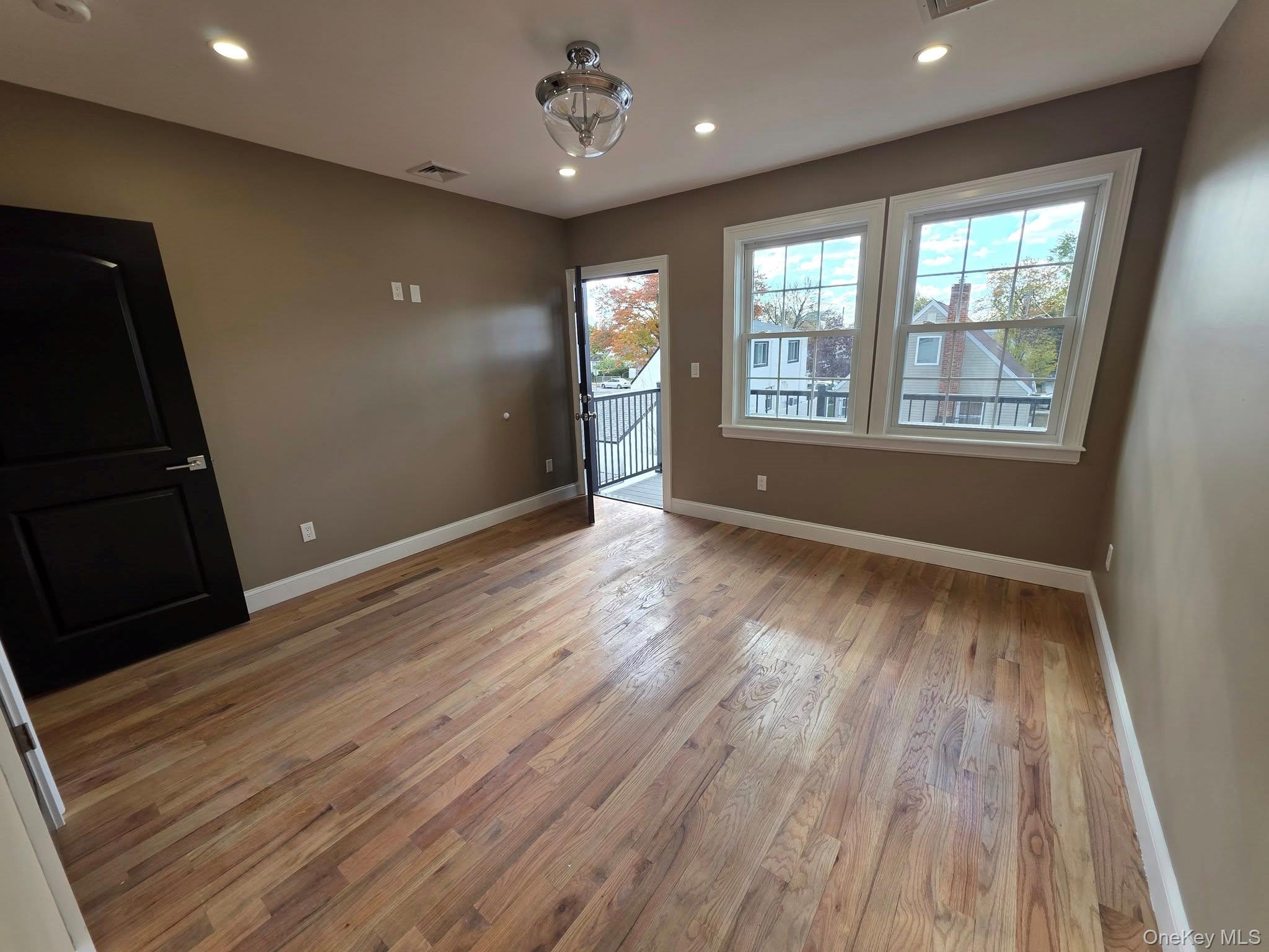 240-02 147th Road Queens, NY 11422 - Photo 7 of 19 a view of an empty room with wooden floor and a window