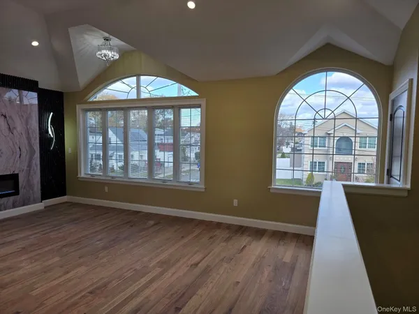 an empty room with wooden floor and window