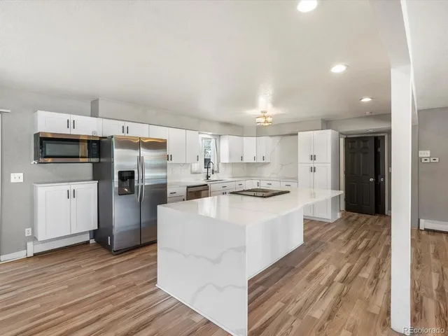 a large white kitchen with a stove a sink and a refrigerator