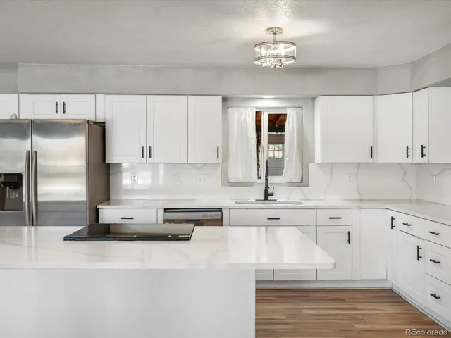 a kitchen with kitchen island white cabinets and stainless steel appliances