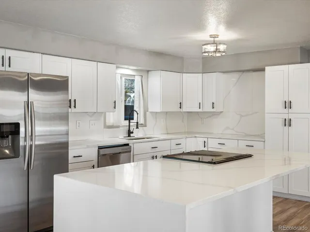 a kitchen with kitchen island a counter top space stainless steel appliances and cabinets
