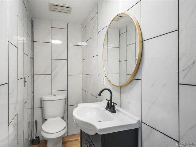 a bathroom with a sink toilet and a mirror