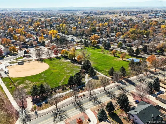an aerial view of residential houses with outdoor space and trees