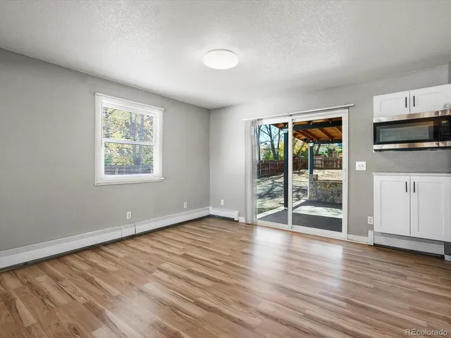 an empty room with wooden floor and windows