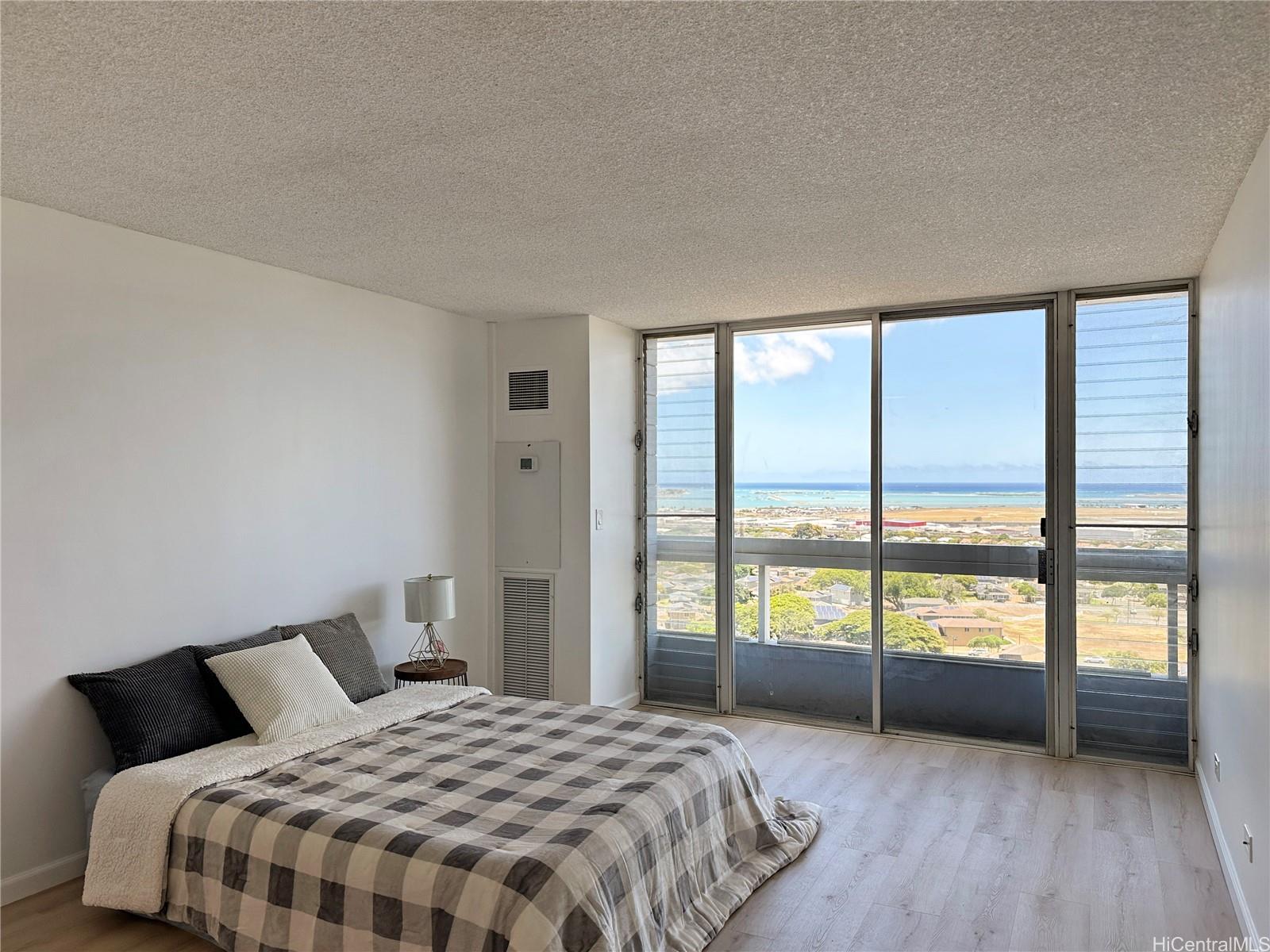 3045 Ala Napuaa Place, Unit 1814 Honolulu, HI 96818 - Photo 1 of 16 a bedroom with a large bed and a large window