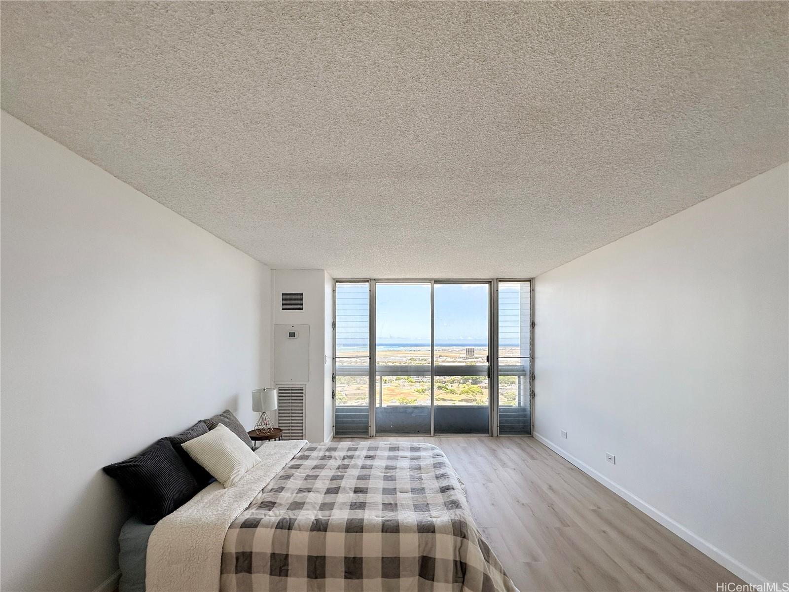 3045 Ala Napuaa Place, Unit 1814 Honolulu, HI 96818 - Photo 2 of 16 a bedroom with a bed and a window