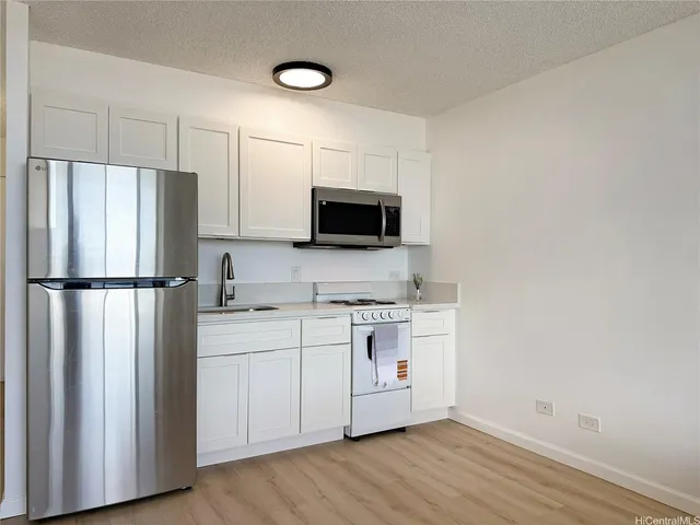 a kitchen with stainless steel appliances a refrigerator microwave and sink