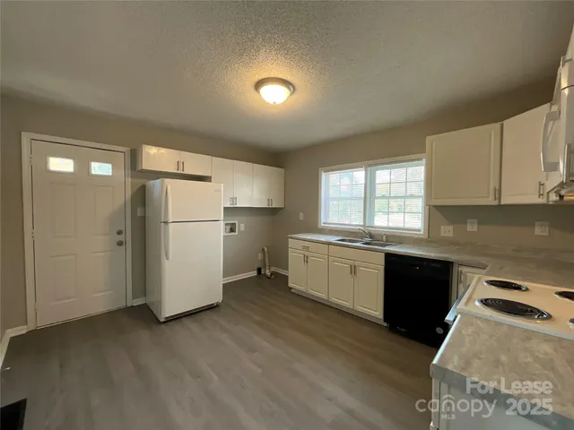 a kitchen with a refrigerator a microwave a sink and cabinets