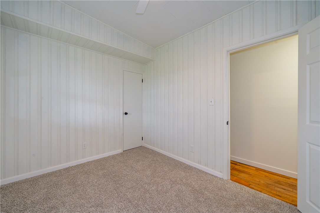 11296 Pansing Road Brookville, OH 45309 - Photo 25 of 53 This cozy bedroom features carpeted flooring and paneled walls, offering a serene and inviting atmosphere.