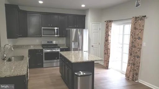 a kitchen with a refrigerator and a stove top oven