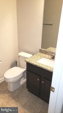 a bathroom with a granite countertop toilet and a sink