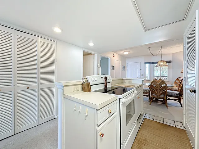 a kitchen with white cabinets and refrigerator