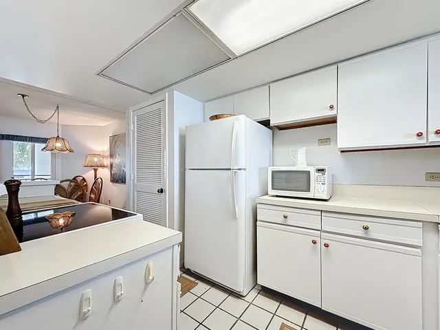 a kitchen with a sink a refrigerator and cabinets