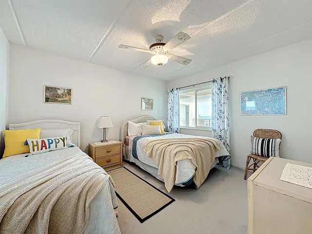 a spacious bedroom with two beds and a chandelier